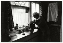 108011 Portret van mevrouw R. Bouman-van Hees in de keuken van haar huis Graanstraat 1 te Utrecht.